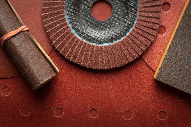 Ahşap ürünleri veya tahtaları temizlemek veya zımparalamak için kullanılan aşındırıcı aletler ve zımpara kağıdı. İnşaat araçları kavramı.