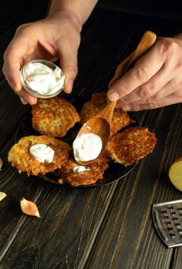 Aşçı kreplere tadı için bir kaşıkla taze ekşi krema ekler. Akşam yemeği için sebze yemeği pişirmek gibi basit bir kavram..