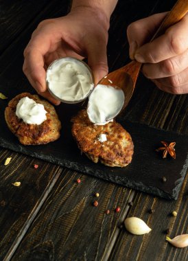 Aşçı pirzolalara tadı için bir kaşıkla ekşi krema ekler. Akşam yemeği için et yemeği pişirmek gibi basit bir kavram..