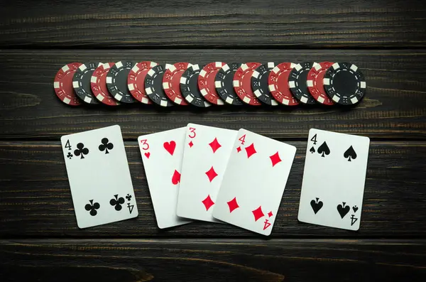 stock image Winning at the poker club. Combination of full house or full boat playing cards and chips on a vintage table.