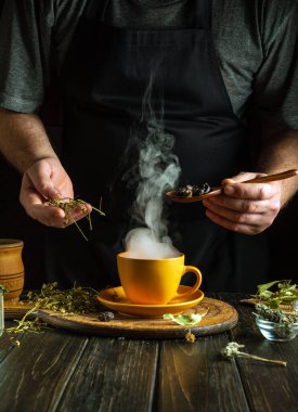 Şifalı bitkilerden çay hazırlayan şifalı bitkiler gül kalçalar ve ev masasında papatya çayı. Geleneksel tıbbın gösterişsiz konsepti.