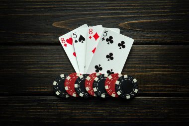 Siyah bir masada iki çift kazanan cips ve iskambil kağıtları. Poker kulübünde ya da kumarhanede kazanma kavramı.