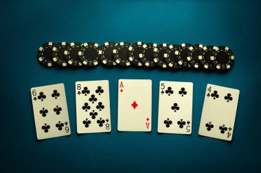 Fişler ve iskambil kağıtları mavi bir masada yüksek kart kombinasyonuyla. Şans kavramı ya da poker kulübünde kazanmak..
