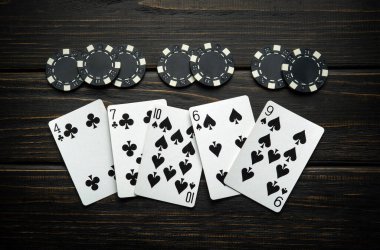 Poker kulübündeki klasik karanlık bir masada kaotik bir şekilde kağıt oynayarak ve siyah çiplerle yatarak. Başarısız kombinasyon ya da kulüpte kaybetme kavramı.