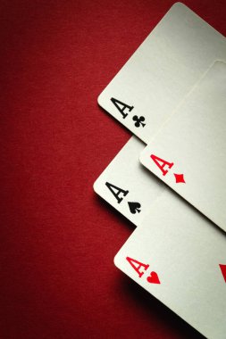 Pokerde dört as ya da dört çeşit dört as kazanan bir kart kombinasyonu. Kumarhanedeki şans ya da servet kavramı kırmızı masada. Reklam için alan.