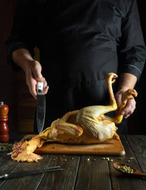 Yemek odasındaki mutfak kesme tahtasındaki çiğ horoz. Mutfakta bir şefin elleriyle tavuk pişirmek..