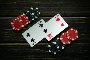 Siyah ve kırmızı çipler ve siyah bir masanın üzerinde kazanan bir çift kart kombinasyonu. Poker kulübünde ya da kumarhanede kazanmak gibi basit bir kavram..