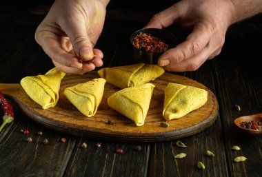 Aşçı kahvaltı için gözleme hazırlıyor. Mutfak tahtasına sarılmış kreplere aromatik baharatlar ekliyorum..
