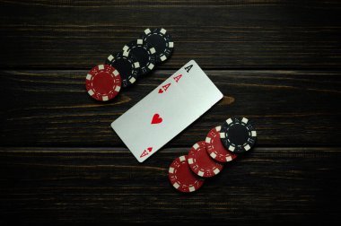 Siyah ve kırmızı çipler ve kazanan kombinasyonlu oyun kartları ya da siyah bir klasik masa. Poker kulübünde ya da kumarhanede üç as ile kazanma kavramı.