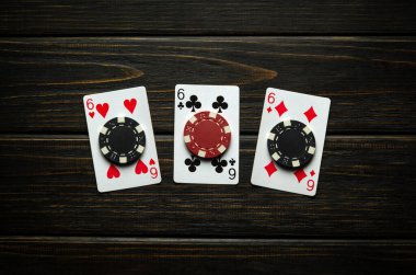 Şans getiren üçlü bir kombinasyonu olan bir kumar poker oyunu. Poker kulübündeki siyah bir masada kart ve fiş oynamak..