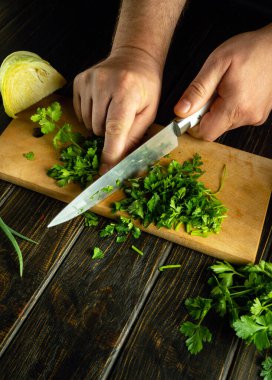 Mutfak masasında bir şefin elleriyle peynirli ve maydanozlu sandviç pişirmek..