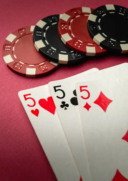 stock image Poker game with three of a kind or set combination. Chip and playing cards on a black table in a poker club.