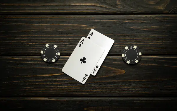 stock image A lucky omen or winning poker hand on a vintage casino table made from two aces and chips.