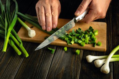 Lezzet ve aroma için yiyeceğe eklemeden önce, şefin elinde bıçakla sarımsak doğramak..