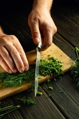 Şef aroma ve enfes tat için besine eklemeden önce yeşil dereotu doğrar..