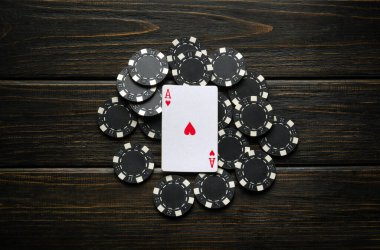Kupa ası ve siyah çiplerle dolu eski bir kulüp masasında şans işareti ya da kazanan poker oyunu düzeni.