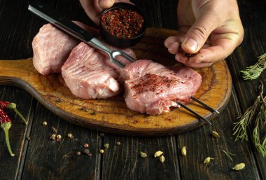 Şef pişirmek için et bifteği hazırlar. Izgaradan önce ete aromatik baharatlar ekliyorum. Asya tarifine göre barbekü yapmak.