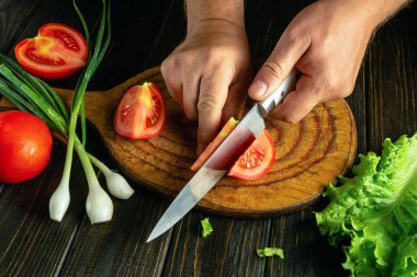 Sebzeli salata ve aşçının elleriyle olgun domates. Domatesli akşam yemeği için diyet menüsü hazırlama fikri.