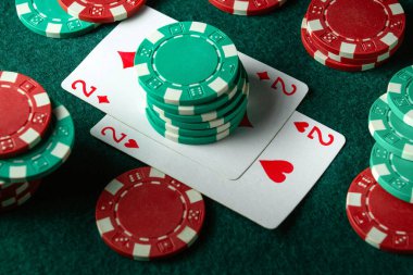 Çok renkli çipler ve masada bir çift kart kombinasyonu. Kulüpte başarılı bir galibiyet kavramı.