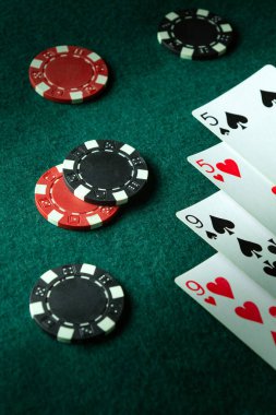 İki çift kâğıt oynamanın şanslı bir kombinasyonu. Poker kulübündeki yeşil masada fişler ve kartlar. Kazancımız servete bağlı..