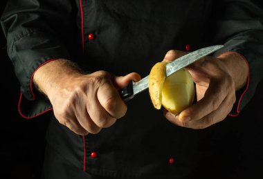 Bir aşçının elinde bıçakla patates soymak. Patates kızartması pişirme hazırlığı kavramı. Diyet yemek pişirmek için basit bir konsept..