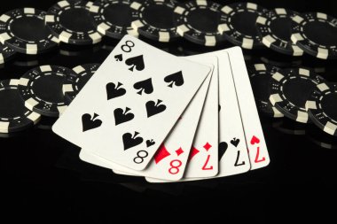 Siyah çipler ve iskambil kağıtları. Kazanan bir kombinasyon. Ya da siyah bir masanın üzerinde tam bir tekne. Şans kavramı ya da poker kulübünde ya da kumarhanede zengin olmak..