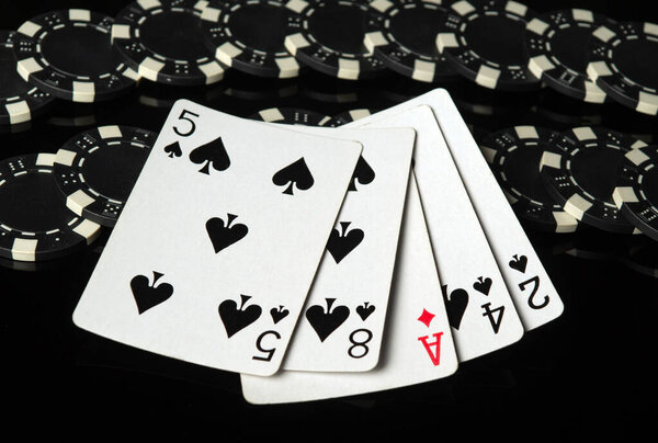 Black chips and playing cards with a winning combination high card on a black table. Concept of luck or rich winning in a poker club or casino.