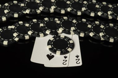 Siyah çipler ve oyun kartları. Siyah bir masada kazanan bir çift. Şans kavramı ya da poker kulübünde iyi bir galibiyet..