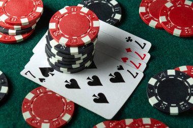 Çok renkli çipler ve kumarhanedeki yeşil bir masanın üzerine rastgele dizilmiş dördünün kombinasyonuyla iskambil kartları. Poker kulübünde başarılı bir galibiyet kavramı..