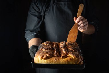 Yetenekli bir fırıncı fırından gururla çıkarılmış sıcak, altın bir somun ekmek sergiler. Atmosfer rahat ve davetkar. Akşam vakti pişirme zevkini somutlaştırıyor..