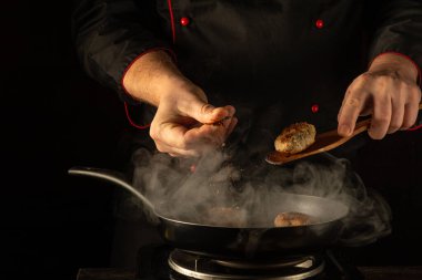 Loş bir mutfakta, yetenekli bir şef lezzetli köfteler pişirir, tavadan buhar yükselirken onları ustalıkla baharatlandırır. Hareketlerine odaklanması aşçılık sanatını gözler önüne seriyor..