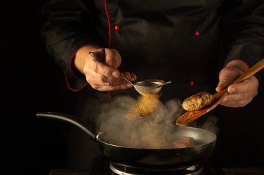 Mutfak ışıklarının sıcacık parıltıları altında yetenekli bir şef, cızırdayan bir tavaya baharat serpiyor. Hava gün batımında aşçılık yaratıcılığının ve tutkunun baştan çıkarıcı kokularıyla doludur..