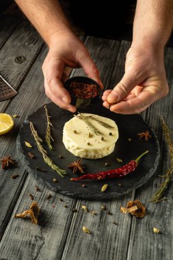 Eller aromatik otlar ve baharatlar katarak yumuşak bir peynir hazırlar. Taze malzemeler canlı bir görüntü yaratarak aşçılığın yaratıcılığını ve lezzetini arttırır..