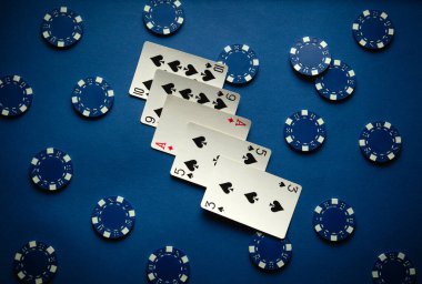 Poker oyunu, yüksek kart kombinasyonlu mavi bir masada oynanır ve büyük zaferin çipleri etrafa saçılır. Oyuncular için gergin bir ortam yaratır..