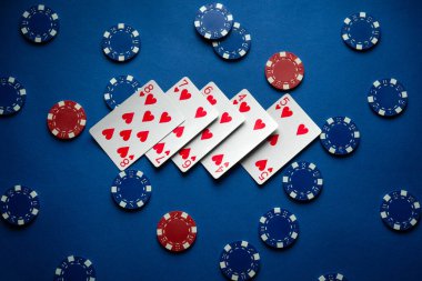 Poker kulübündeki mavi masa, kart ve fiş kazanma kombinasyonuyla dolu. Kumar büyük para kazandırır..