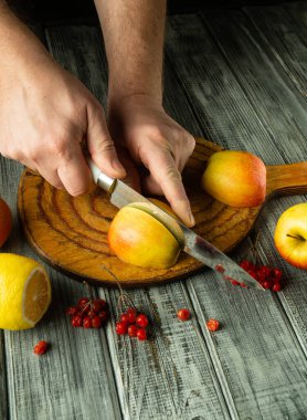 Lezzetli limonlar ve parlak böğürtlenlerle çevrili taşralı ahşap bir tahtanın üzerinde ustaca kesilmiş elmalar. Sıcak atmosfer aşçılık yaratıcılığı ve mevsimsel zevkleri ima ediyor..