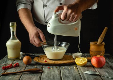 Bir şef, taze meyve ve mutfak malzemeleriyle çevrili karışımı ustalıkla karıştırır. Atmosfer davetkar, mutfak yaratıcılığı için mükemmel..