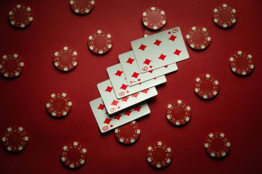 Poker kulübündeki masada kırmızı çipler ve floş kombinasyonlu iskambil kartları var. Kumarda büyük galibiyet kavramı.