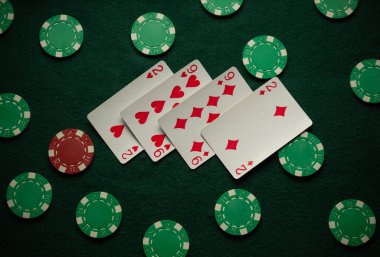 Kupa ve elmasları gösteren dört iskambil kartı çeşitli poker fişleri ile çevrili yeşil bir keçeli masaya yerleştiriliyor ve oyun gecesi için davetkar bir ortam yaratıyor..
