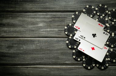 İskambil kağıtları yıpranmış ahşap bir yüzeye dizilmiştir. Siyah poker çipleriyle çevrili dört as sergilenmektedir. Bu da ciddi bir poker oyunu olduğunu gösterir..