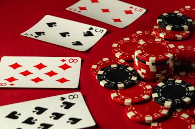 İki çiftten oluşan bir grup oyun kartları ve poker fişleri kırmızı bir masaya yerleştiriliyor ve bu da dostça bir oyun akşamı boyunca heyecan yaratıyor. Pokerde iyi ya da şanslı bir galibiyet.