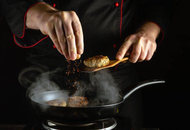 Bir şef, kızartma tavasında cızırdayan köftelere ustalıkla baharat ekler ve gece pişirme oturumunda buharla dolu bir mutfakta lezzetli aromalar üretir..