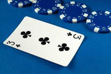 Sinek üçlüsünün kartı canlı mavi bir yüzey üzerinde birkaç mavi poker çipinin yanında bulunur. Kurulum arkadaşlarla oyun gecesi için çekici bir atmosfer öneriyor..