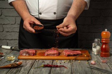 Ahşap bir tahtanın üzerine taze et parçaları serpiştiren bir şef. Kırsal mutfak atmosferi yemek pişirme sürecine odaklanmayı artırıyor, aşçılık becerileri ve tatları vurguluyor.