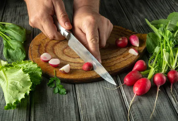 Turpları ve yapraklı yeşillikleri taze ürünlerle çevrili ahşap bir tahtanın üzerinde ustalıkla dilimlemek. Canlı renkler ve doğal ışık bileşenlerin tazeliğini vurgular..