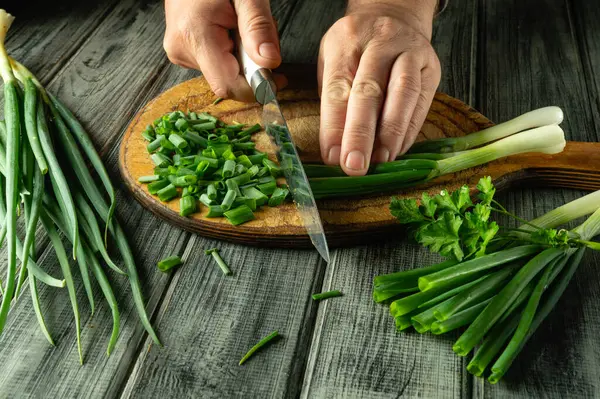 Eller ustalıkla taze soğan ve kişniş doğruyor. Köy mutfağında doğal ahşap dokular ve canlı yeşiller sergileniyor..