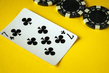 Sinek yedili kart, birkaç siyah kumarhane çipinin yanında canlı sarı bir yüzeye yerleştirildi. Dostlar arasında oyun gecesi için canlı bir atmosfer yarattı..