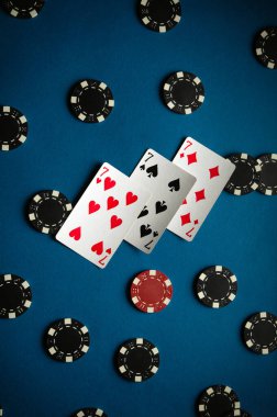 Oyun masasında üç yedili ve poker kazanmaktan kalma oyun fişleri var. İki çift kart ve bir oyun akşamı için mükemmel bir atmosfer sergiliyorlar..
