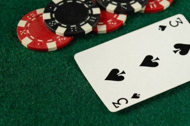 Yeşil keçeli masa üstü, poker fişleri ve iskambil kağıtlarını gösteriyor. Kahkaha ve stratejiyle dolu heyecanlı bir oyun gecesine zemin hazırlıyor..