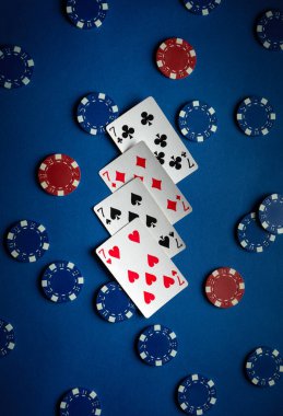 Kupa, maça ve poker çiplerinin yer aldığı bir oyun kartı seti mavi bir masada düzenlenerek oyun gecesi için heyecan verici bir atmosfer yaratılıyor. Dört yedili..